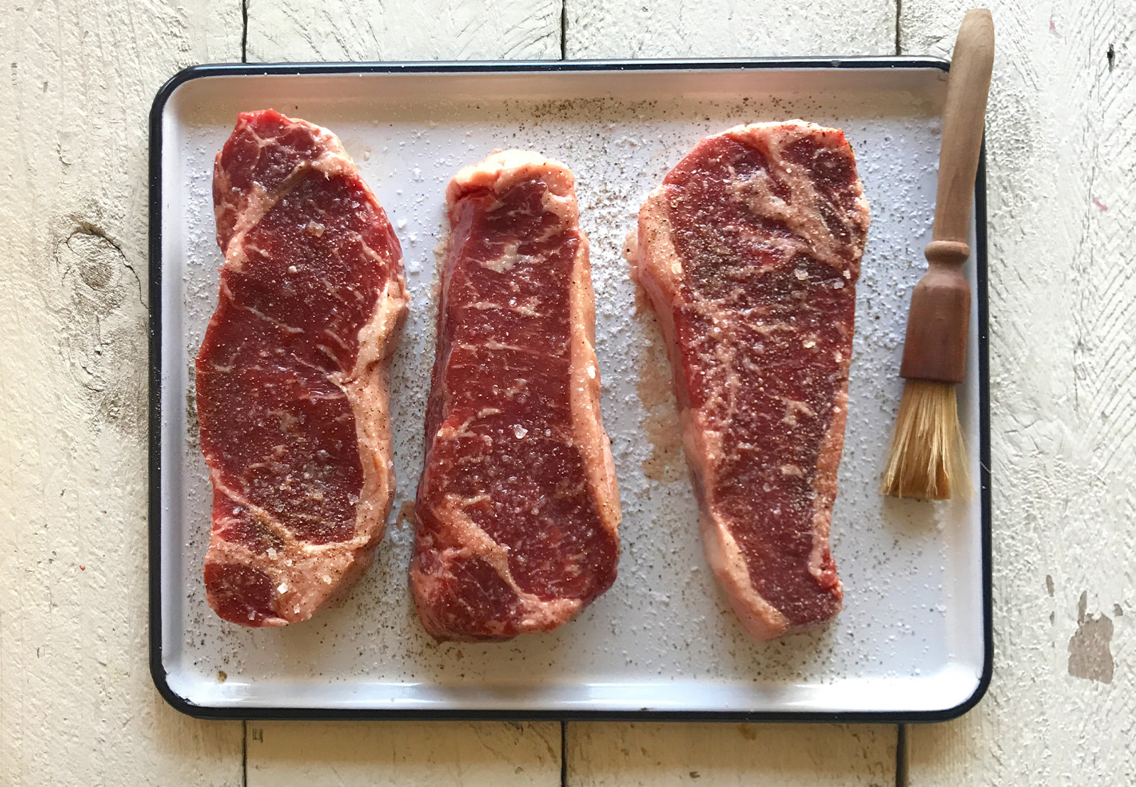 Three steaks seasoned with salt
